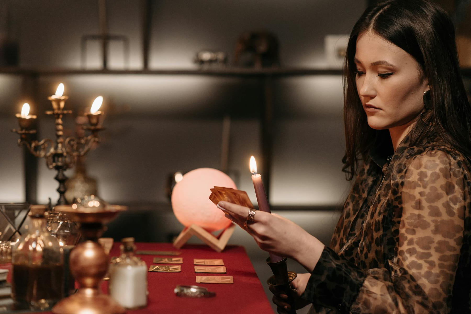 A woman engages in a mystical tarot reading by candlelight, creating an enchanting atmosphere. on The Manifesting Light