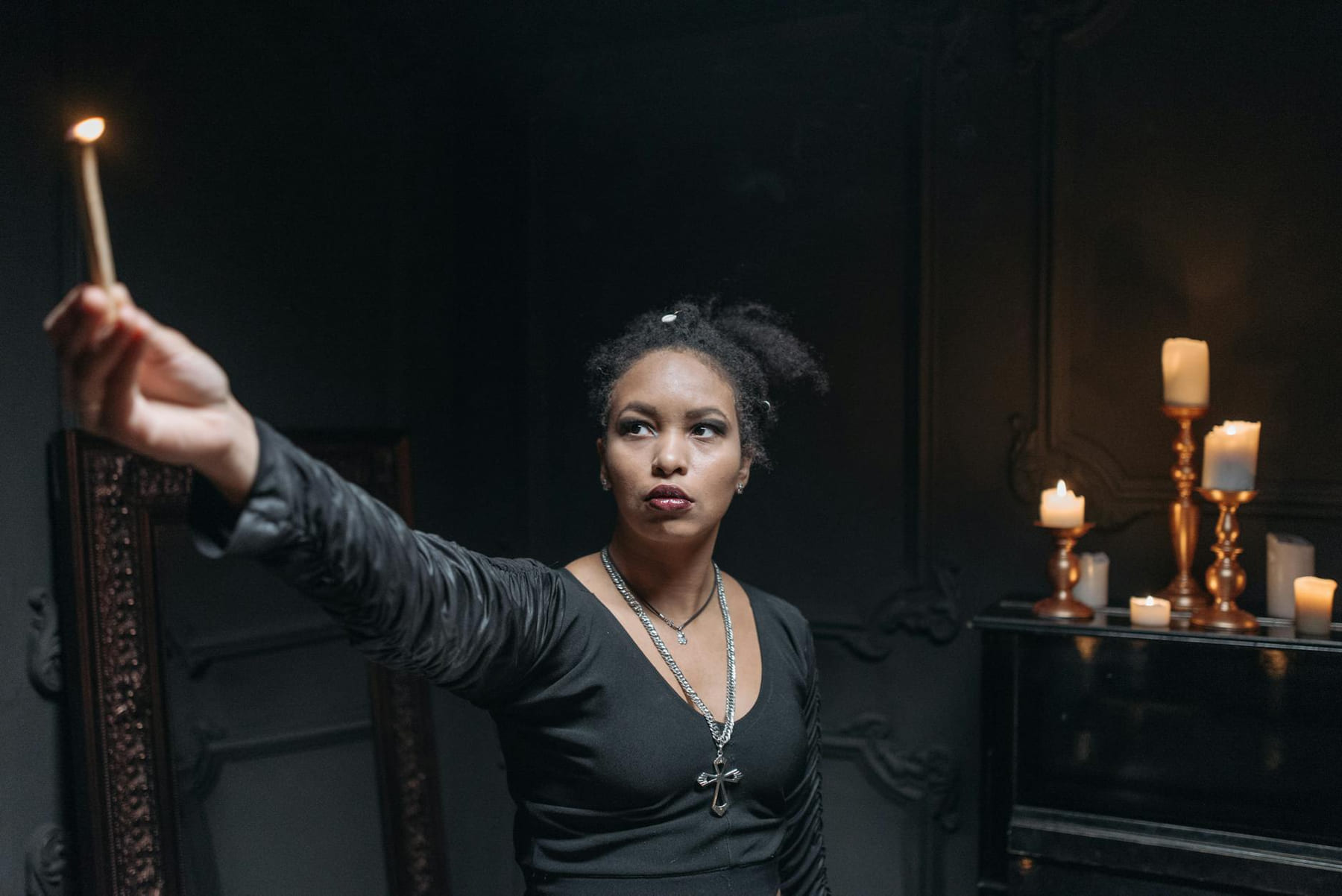A young woman holding a burning candle in a dimly lit room with a mystical, spiritual atmosphere. on The Manifesting Light