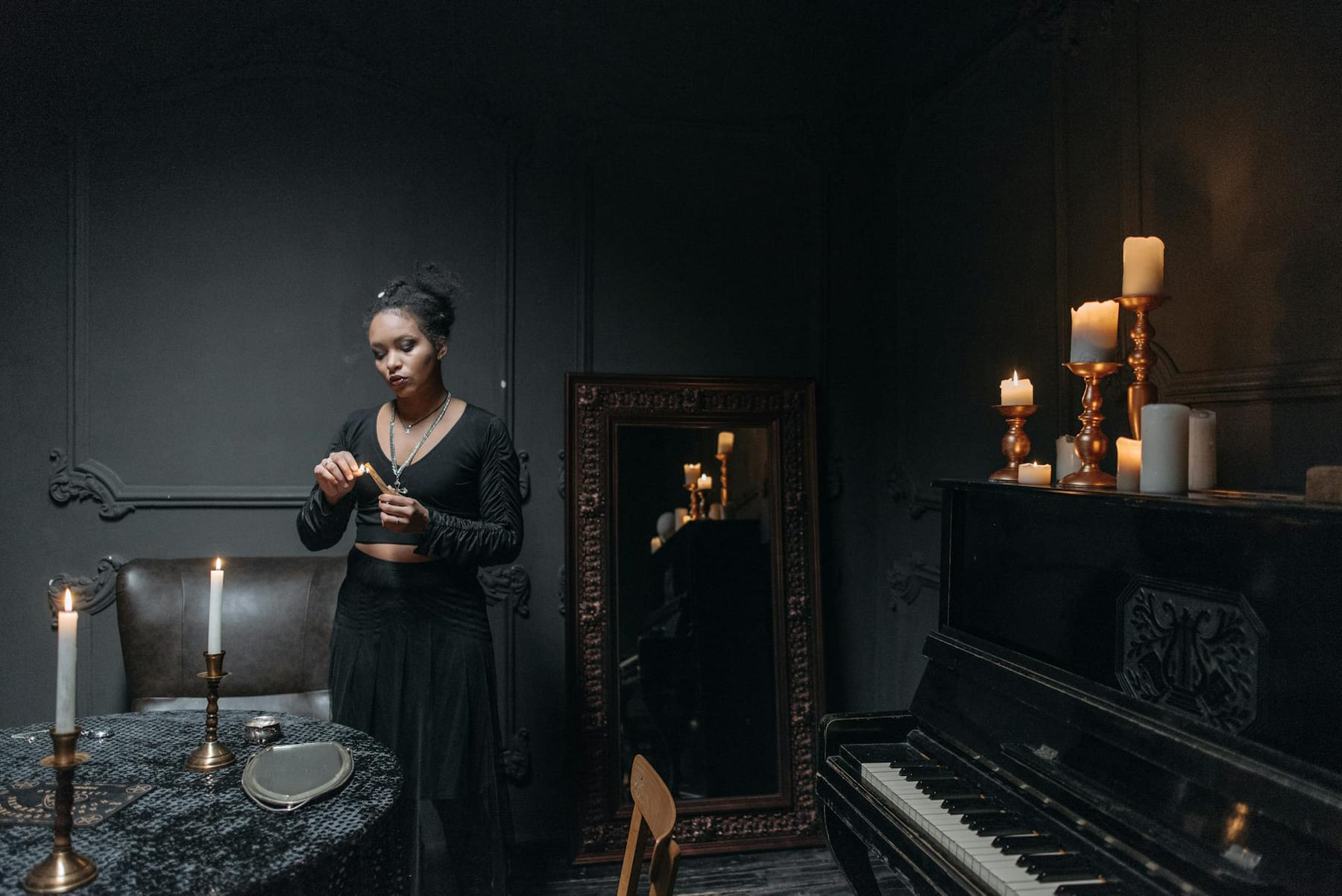 A woman conducts a seance in a dimly-lit room with candles, reflecting a mystical atmosphere. on The Manifesting Light