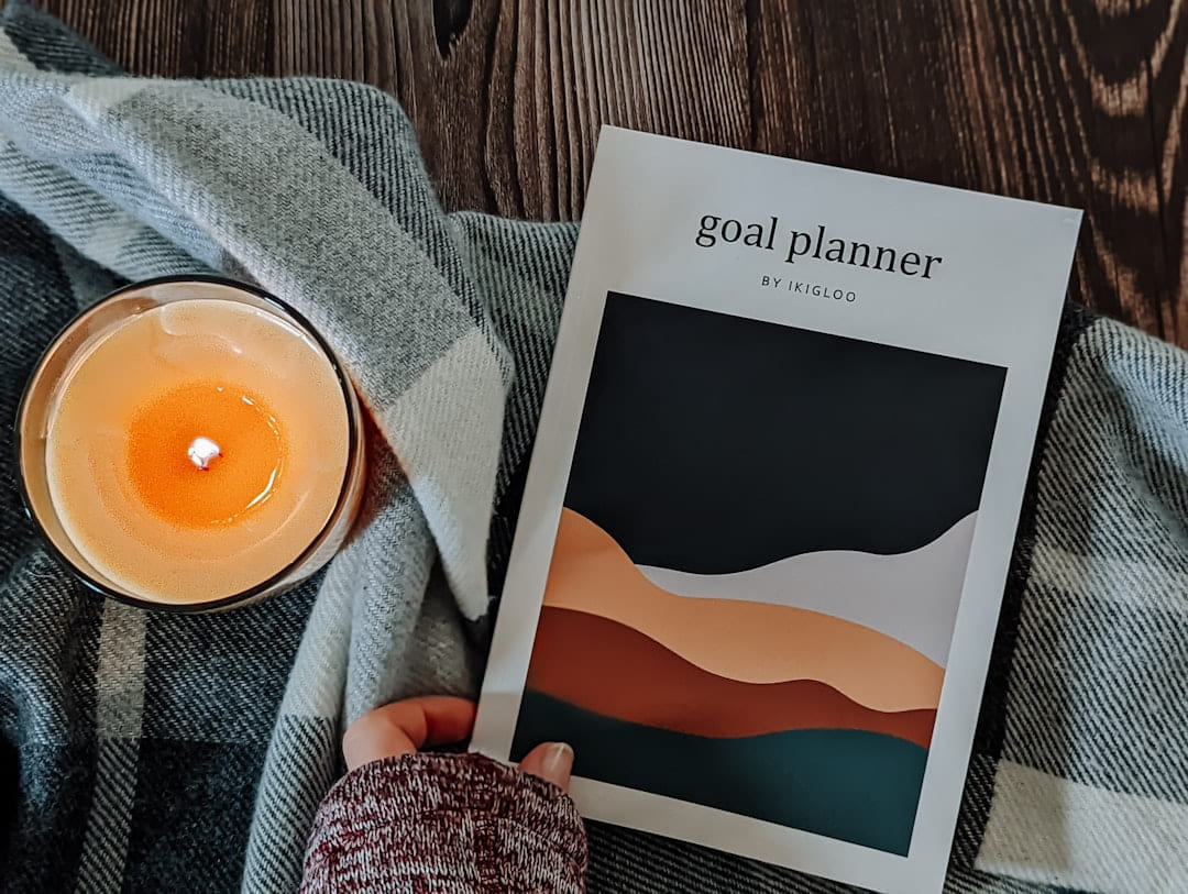 a person holding a book next to a candle on The Manifesting Light